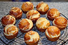 a wire rack filled with buns covered in frosting