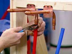 a person is working on some kind of wooden structure with pliers and other tools