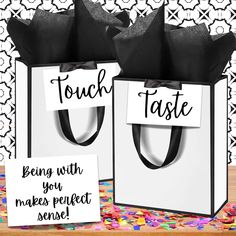 two black and white paper bags with tags on them that say, touch taste being with you makes perfect sense