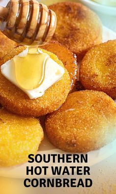 a white plate topped with fried cornbreads covered in butter and syrup next to a honey dip