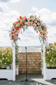 an outdoor wedding setup with flowers on the arch