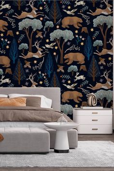 a bed sitting in a bedroom next to a night sky wallpaper covered in animals