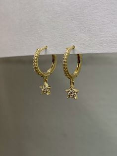 925 sterling vermeil CZ star charm huggie hoop earrings. 14KT gold plate over sterling silver. Cubic zirconia stones. Hoops measure 12mm in diameter. Star charm measures 5mm. Hinge style hoop with latch back. Hoops sold as a pair. Please note due to hygiene reasons, and for the safety of our customers and employees, pierced earrings are not returnable. Please make sure the sizes work for you! Follow us on instagram @pennyweightsjewelry! Yellow Gold Star-shaped Tarnish Resistant Huggie Earrings, Gold Star Charm Hoop Earrings, Gold Plated Star Hoop Earrings Tarnish Resistant, Gold Plated Star Hoop Earrings, Gold Plated Star-shaped Hoop Earrings, Gold Plated Star Shaped Hoop Earrings, Gold Dainty Huggie Earrings With Star Charm, Star-shaped Gold Plated Hoop Earrings In Yellow Gold, Dainty Yellow Gold Huggie Earrings With Star Charm