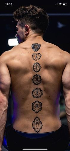 the back of a man's body with seven chakras tattooed on it