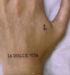 a person's left hand with the word la dolce vita tattooed on it