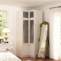 a white bedroom with a large mirror in the corner