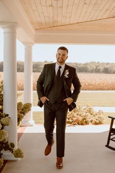 a man in a suit and tie standing on a porch