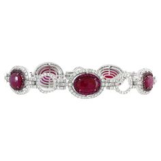 This exquisite link bracelet is a harmonious blend of rich rubies and dazzling diamonds, exuding luxury and sophistication. Crafted in 18k white gold and weighing 22 grams, it combines elegance with a contemporary design. The bracelet features 5 oval-shaped rubies totaling 4.77 carats, each encircled by two halos: an inner layer of 115 round rubies totaling 1.34 carats, and an outer layer of sparkling white round diamonds totaling 3.2 carats. These radiant units are meticulously set in an intric 2 Carat, Link Bracelets, Timeless Beauty, Diamond Bracelet, Round Diamonds, Contemporary Design, Halo, Ruby, Jewelry Bracelets