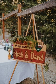 a wooden sign that says welcome to our adventure held and david on it's easel