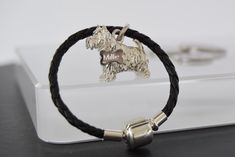 a black leather bracelet with a silver dog charm