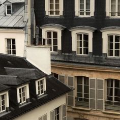 two buildings with white windows and black roofs