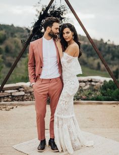 a man and woman standing next to each other in front of a teepeel