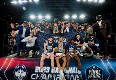 the men's basketball team poses for a photo with their trophy