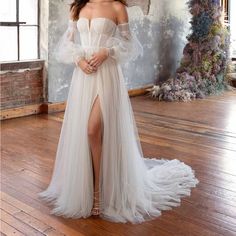 a woman in a white dress standing on a wooden floor