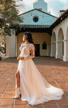 a woman in a white dress is standing on a brick walkway and posing for the camera