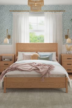 a bed sitting under a window in a bedroom next to a dresser and lamp on top of a rug