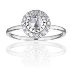 a white gold ring with an oval cut diamond surrounded by small round diamonds on the band