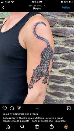 a man with a tattoo on his arm that has a leopard on it and is wearing a black tank top