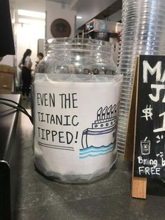 a glass jar with some writing on it sitting next to a sign that says even the atlantic tripped