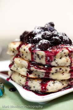 a stack of pancakes covered in blueberry sauce