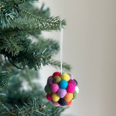 a colorful ornament hanging from a christmas tree