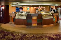 the inside of a starbucks coffee shop with lots of counter space and lights on it