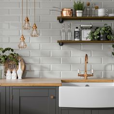 a kitchen with grey cabinets and white brick walls