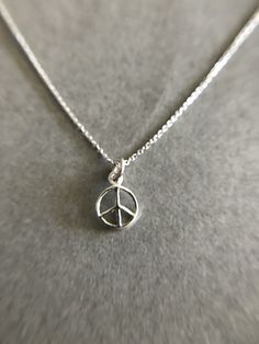 "Tiny Mini Peace Silver Necklace - Sterling Silver Color : Silver Material : Sterling Silver Peace Size : 8mm Chain Length : 16\" / 18\" / 20\" * Metal components are Sterling Silver. * Suitable for delicate and sensitive skin. * Comes in a jewelry box. If you need extra boxes for gifting....just let us know!" Silver Peace Sign Jewelry Gift, Peace Sign Jewelry For Gifts, Silver Round Charm Necklace 16 Inch, Symbolic Hypoallergenic Necklace With Round Pendant, Hamsa Necklace, Hippie Necklace, Necklace Sterling Silver, Sterling Earrings, Bridal Earrings