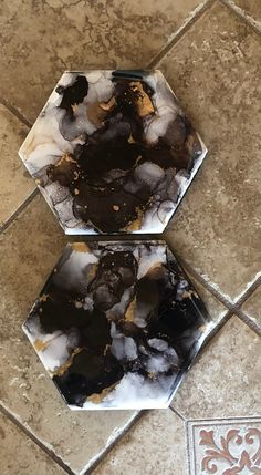 two black and white plates sitting on top of a tile floor