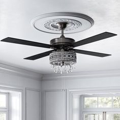 the ceiling fan is hanging from the ceiling in the room with white walls and windows