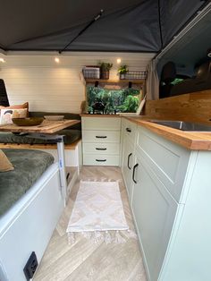 the inside of a camper with white cabinets and drawers