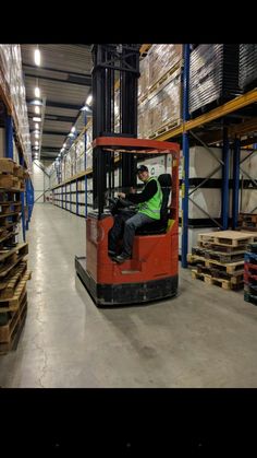 a man driving a forklift in a warehouse