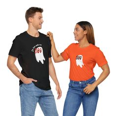 Get spooky and cute this Halloween with our "I'm Here With My Boo" Bella + Canvas 3001 t-shirt, designed for couples looking to make a haunting entrance together! This playful, Halloween-inspired tee features the phrase "I'm Here With My Boo," with the two O's cleverly transformed into ghostly eyes, adding a fun and eerie touch to your look. Pair it with our matching "Boo" shirt, featuring the same ghost-eye design, to complete a perfectly coordinated couple's Halloween party costume. 👻 Premium Quality: Made from 100% combed and ring-spun cotton, this Bella + Canvas 3001 t-shirt offers unbeatable softness and durability. The lightweight fabric and comfortable fit make it ideal for all-day wear, whether you're at a Halloween party or enjoying festive activities. 🎃 Fun Halloween Design: Th Pre-shrunk Short Sleeve T-shirt For Halloween, Unisex Pre-shrunk Halloween T-shirt, Festive Activities, Halloween Party Costume, Boo Shirts, My Boo, Couples Halloween, Halloween Party Costumes, Halloween Tees