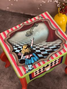 a small table with a painting on it in the shape of a girl holding a key