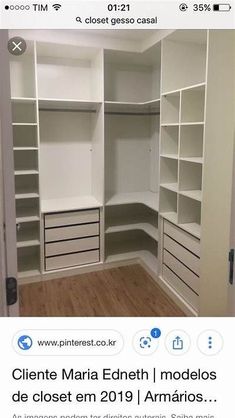 an empty closet with white shelves and drawers on the bottom, in front of a wooden floor