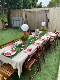 a table set up for a party with red and white plates, napkins and paper lanterns