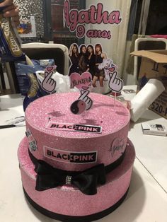 a pink hat with black bow on top sitting on a table next to other items