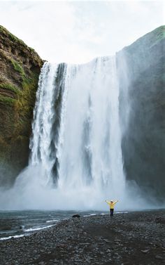 a person standing in front of a waterfall