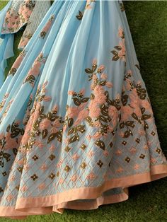 This traditional ensemble is detailed with thread work and a glance of light gold work on the lehenga and blouse. This outfit is completed with a contemporary look of a ruffle dupatta. Traditional Semi-stitched Gown With Floral Embroidery, Semi-stitched Saree Dress With Intricate Embroidery, Unstitched Embroidered Chinon Gown, Festive Georgette Gown With Floral Embroidery, Floor-length Anarkali Set With Intricate Embroidery For Festivals, Traditional Georgette Gown With Resham Embroidery, Traditional Georgette Gown With Intricate Embroidery, Traditional Gown With Resham Embroidery In Georgette, Designer Gown With Intricate Embroidery For Navratri