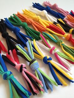 many different colored tassels laid out on a white counter top with one knoted at the end