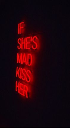 a red neon sign that says if she's mad, kiss her