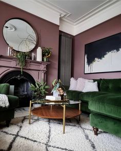 a living room filled with green couches and a round coffee table in front of a fireplace