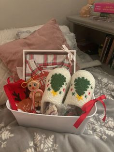 a white basket filled with christmas items on top of a bed