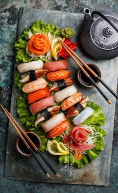 sushi platter with chopsticks and vegetables on it, ready to be eaten