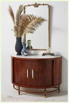 a wooden cabinet with two vases and a mirror