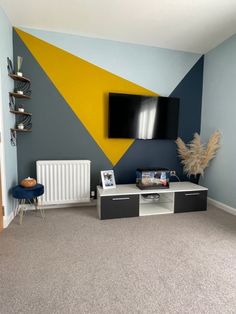 a television mounted on the wall in a living room next to a radiator