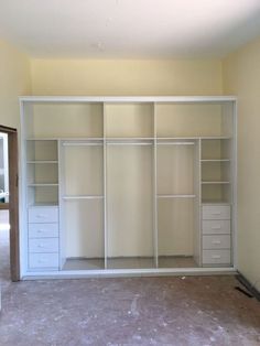 an empty room with white closets and drawers in the middle, no one is present