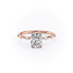 a rose gold engagement ring with an oval cut diamond in the center and side stones