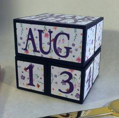 a close up of a wooden block with the numbers thirteen on it and flowers painted on it