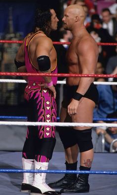 two men standing next to each other in a wrestling ring